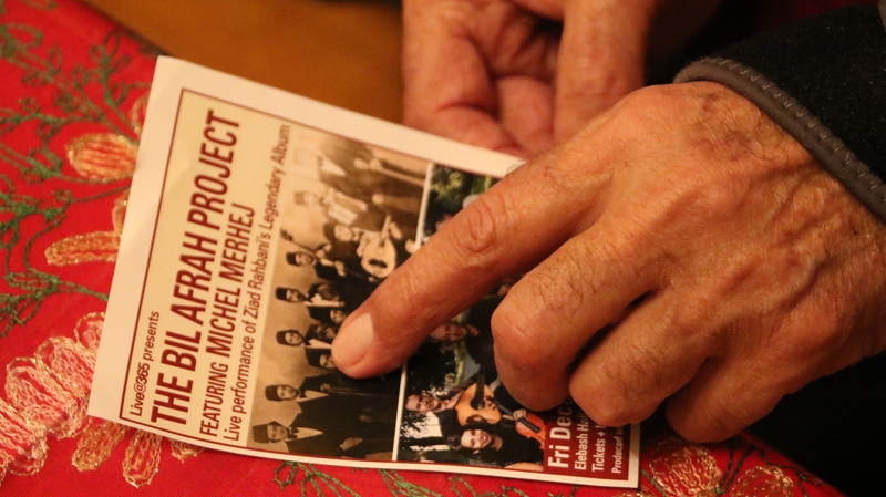 ميشيل مرهج بقلوق يشير لصورته على غلاف ألبوم بالأفراح في منزله في نيويورك في شهر ديسمبر 2018.